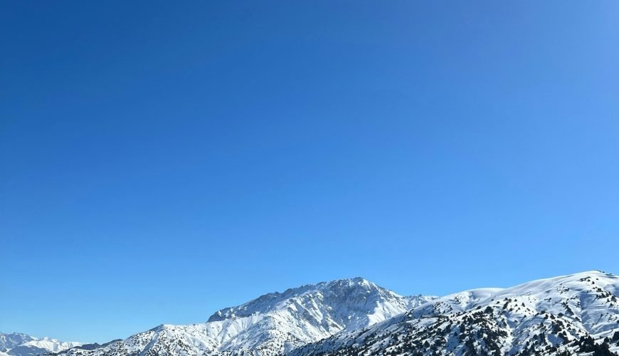 a view of a snowy mountain range from a ski lift