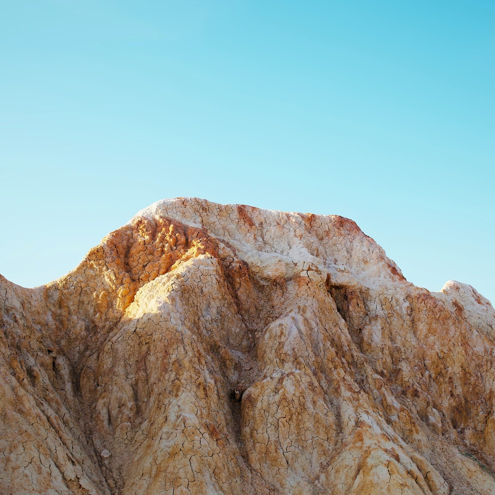 A view of a mountain range with a blue sky in the background