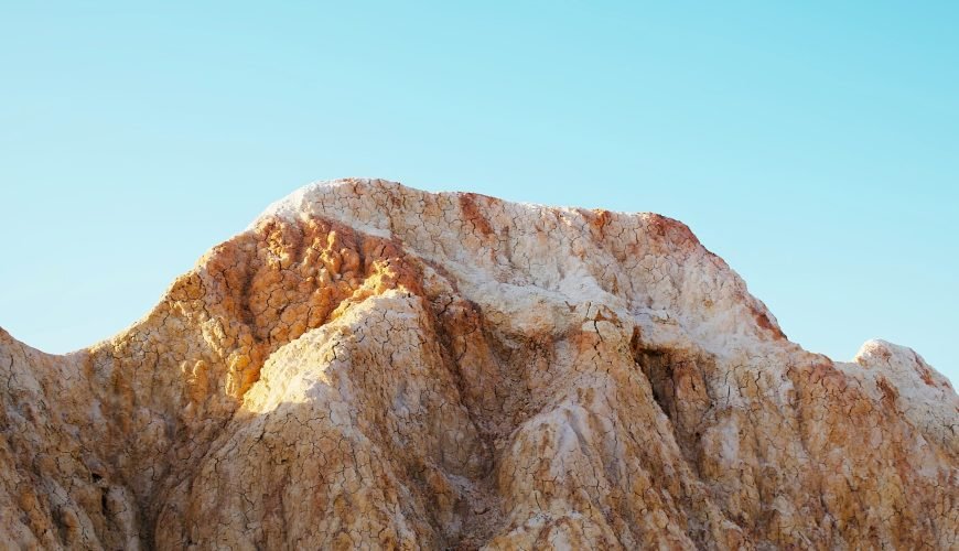 A view of a mountain range with a blue sky in the background