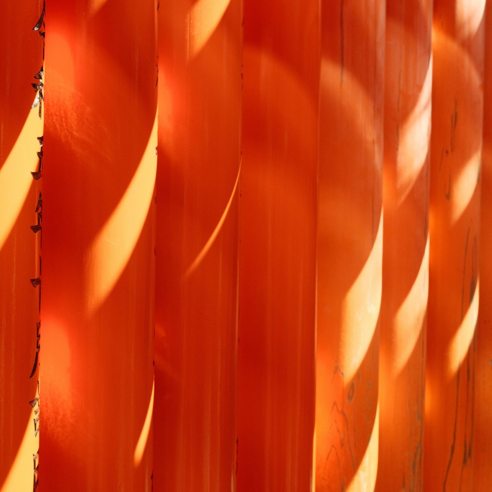 a close up of an orange wall with long shadows