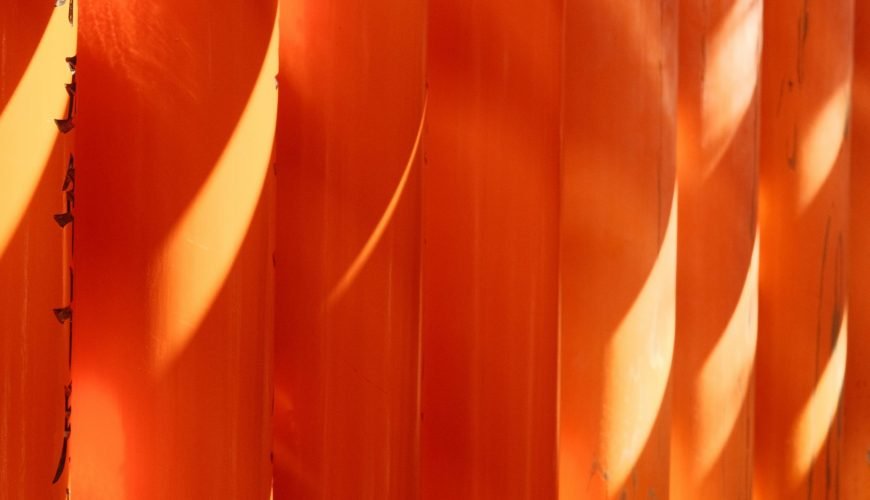 a close up of an orange wall with long shadows