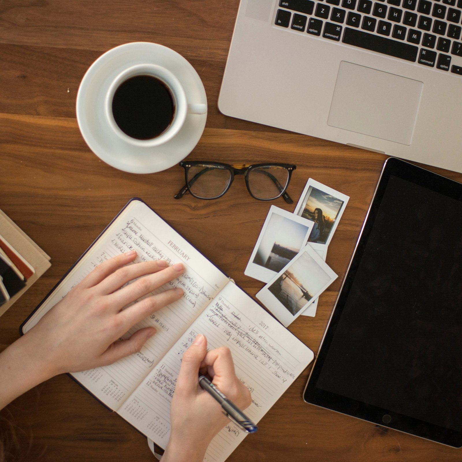 person holding ballpoint pen writing on notebook