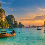 خليج استوائي في تايلاند بقوارب تقليدية وجزر صخرية ومياه فيروزية